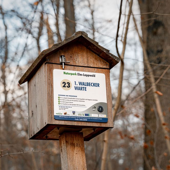Kleines Häuschen aus Holz, welches die Stempelstation der der Walbecker Warte ist, wie auf einem an dem Häuschen befestigten Schild deutlich wird
