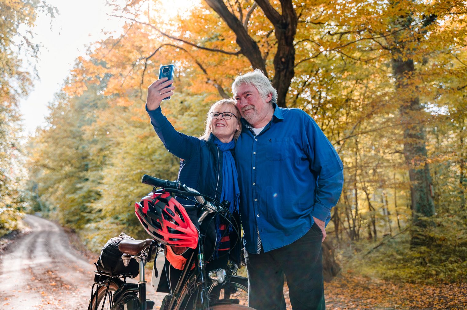 Zwei Radfahrer stehen neben ihren Rädern und machen ein Selfie mit dem Smartphone