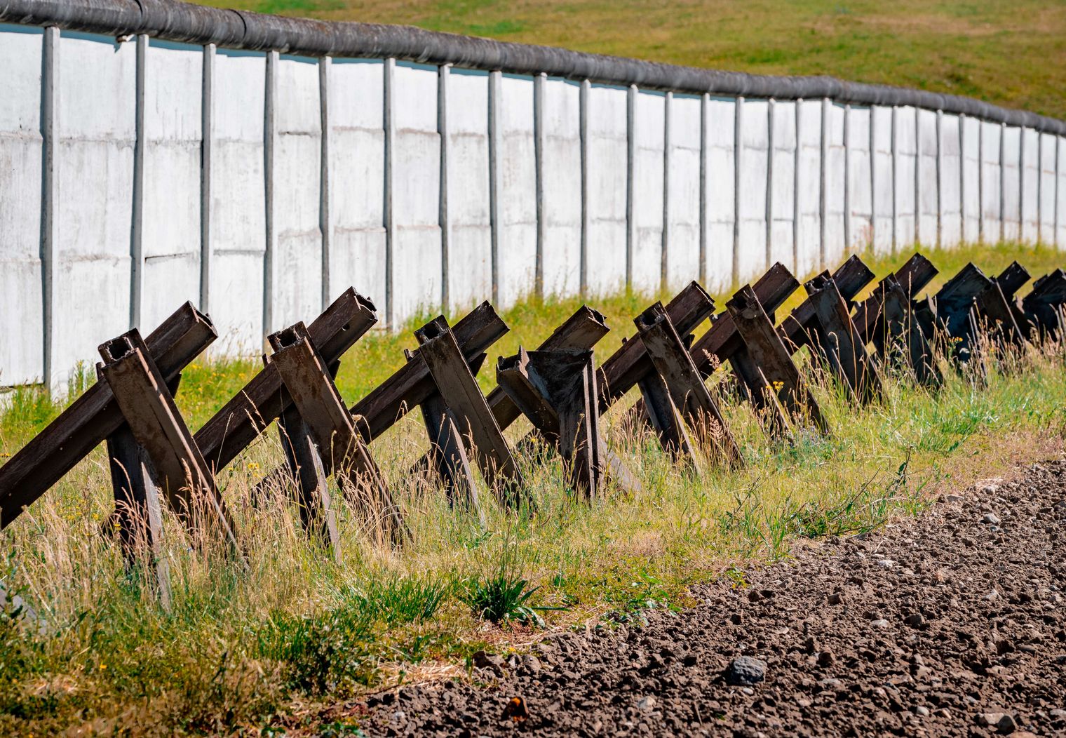Ehemalige Fahrzeugsperren der Grenzanlage Hötensleben und im Hintergrund die Mauer